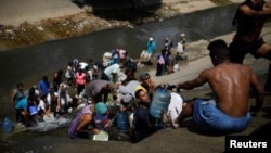 Жители обесточенного Каракаса, где нет и водоснабжения, собирают жидкость из городской сточной канавы
