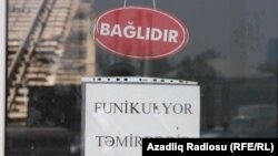 Şüşəsi qırılmış qapıya «Funikulyor təmirdədir» yazılmış elan