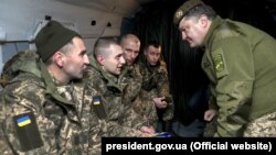 Украина президенті Петр Порошенко (оң жақта) тұтқыннан босатылған украиндықтармен кездесіп тұр. 27 желтоқсан 2017 жыл.