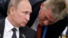 Russian President Vladimir Putin's spokesman, Dmitry Peskov (right), has been busy this week issuing nondenials on his boss's behalf. (file photo) 