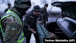 Украина қауіпсіздік қызметкерлері Мариупольге жақын бақылау бекетінде көлікті тексеріп жатыр. 27 қараша 2018 жыл.