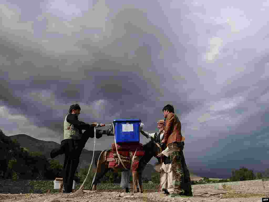 More than 17 million eligible voters are expected to participate in the vote, which is complicated by Afghanistan's vast and challenging geography. Villagers load a donkey with election supplies for a remote village in the Panjshir Valley.