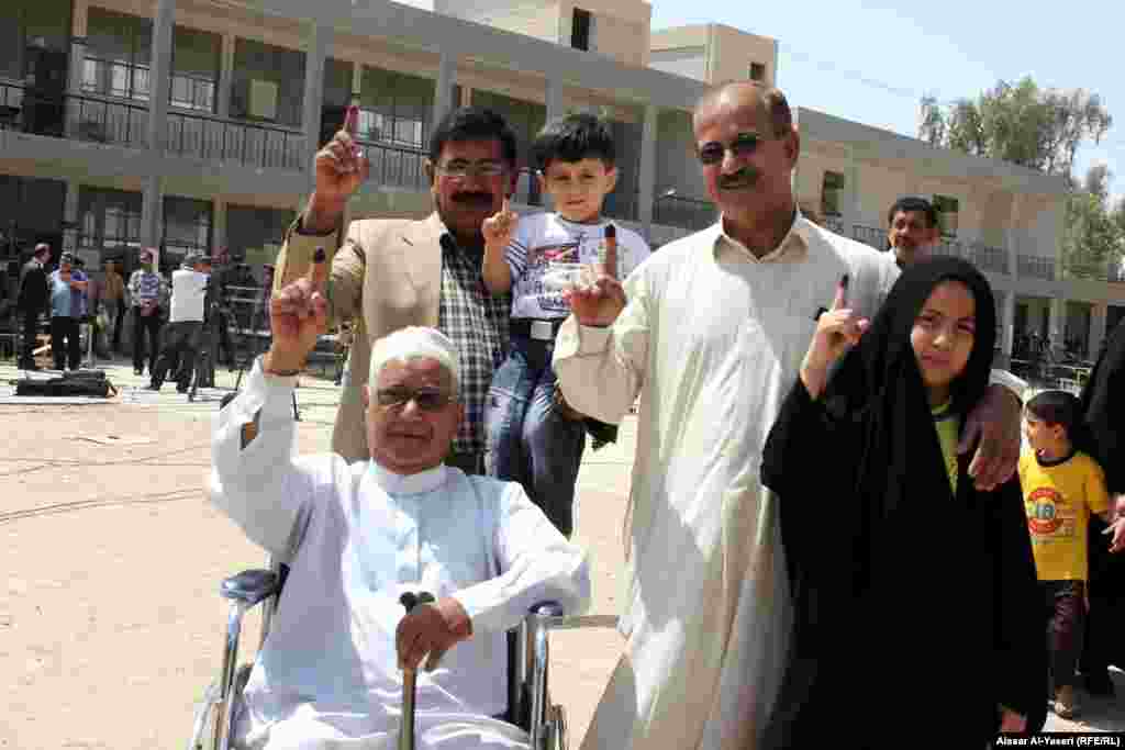 People show their ink-stained fingers after casting their votes during provincial council elections in Najaf.