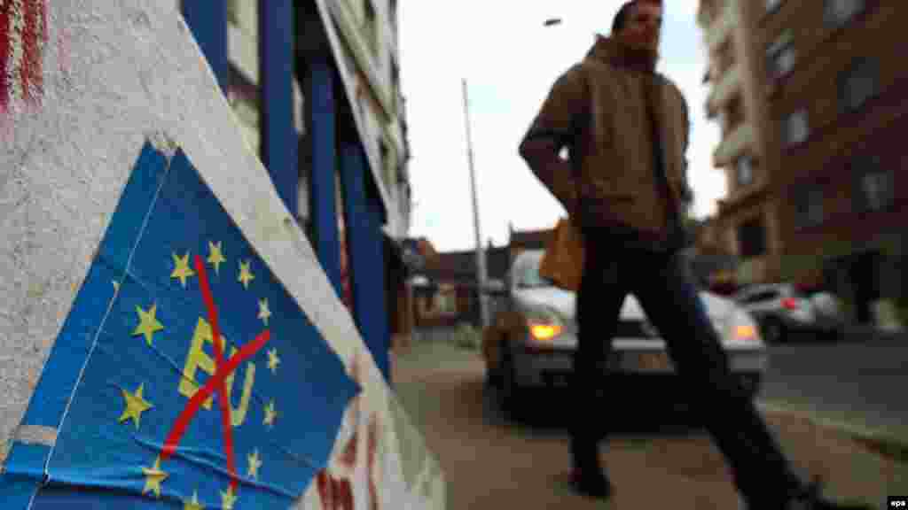 A man passes posters in Belgrade on February 28 reading, &quot;We don&#39;t want the EU.&quot; (epa/Koca Sulejmanovic)