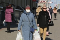 Многие люди предпочитают ходить в масках. Фотография сделана в Минске 5 апреля