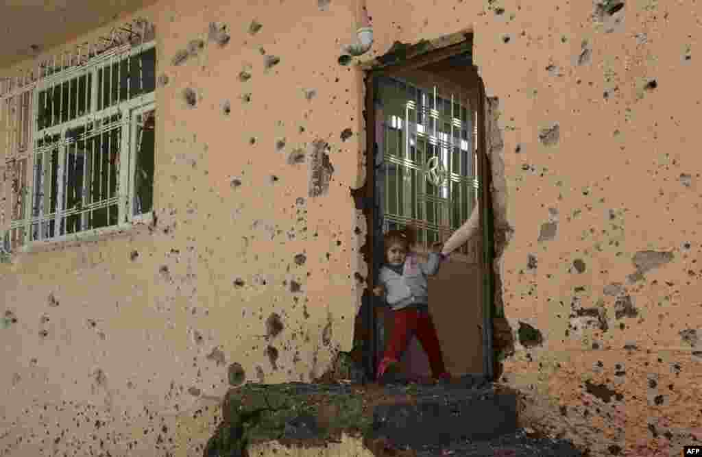 A girl stands at the entrance of a damaged house in the Sur district in Diyarbakir, Turkey. The province has been under military curfew for eight days as Ankara wages an offensive against PKK strongholds in the southeast of the country and in northern Iraq following the collapse in July of a two-year truce with rebels. (AFP/Ilyas Akengin)