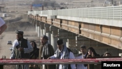 Afghans cross a bridge over the Pyanj River into Tajikistan and the the town of Lower Pyanj. (2007 photo)