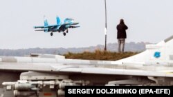 A journalist takes a picture of a Ukrainian Sukhoi Su-27 jet fighter during the Clear Sky 2018 military exercise on October 12.