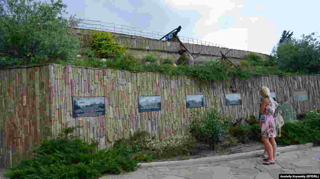 На подпорной стене у входа на территорию комплекса прикреплены гранитные доски с изображением известных затонувших судов