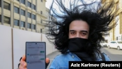 Čovek u Bakuu pokazuje svoj mobilni telefon s dozvolom za napuštanje kuće, dobijenom u SMS poruci, pošto su azerbejdžanske vlasti u aprilu uvele oštra ograničenja na kretanje tokom pandemije COVID-19.