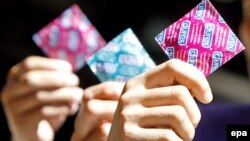 Philippines -- young men hold up Durex brand condoms. 12Nov2009