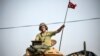 یک نیروی نظامی ترکیه در حومه جرابلس، پرچم این کشور را بر فراز تانک به اهتزاز در آورده است.