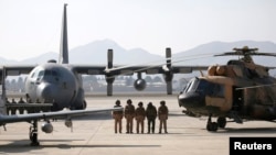 Afghan pilots stand among aircrafts during the Afghanistan Air Force readiness performance program at a military airfield in Kabul, February 2016.