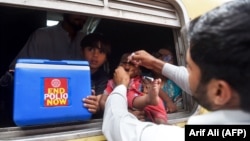 FILE: A Pakistani health worker administers polio vaccine drops to a child during a polio vaccination campaign at a railway station in the eastern city of Lahore on May 16.