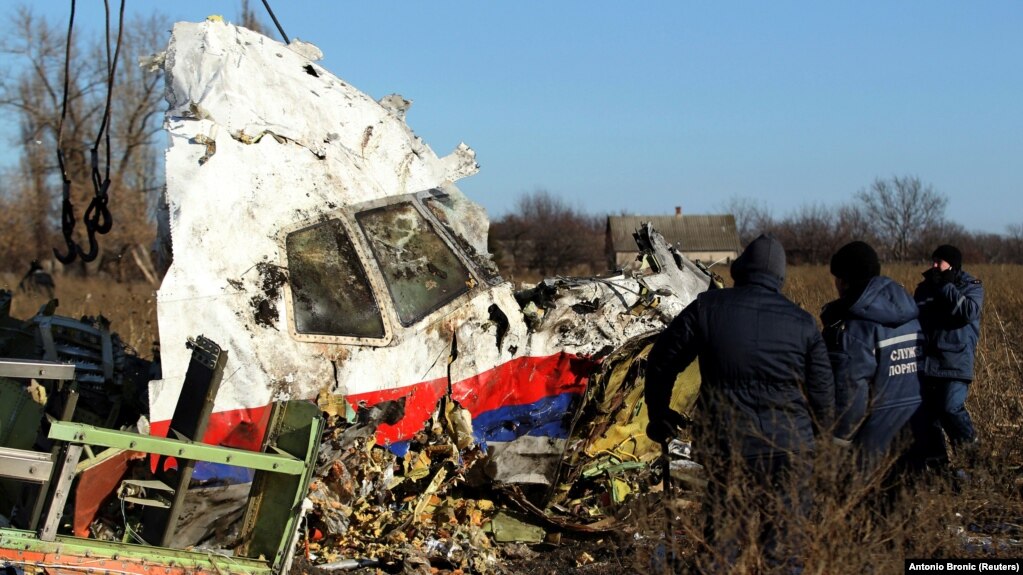 Local workers clear a piece of wreckage from Malaysia Airlines flight MH17 near the village of Hrabove after the plane was shot down over Ukraine in 2014, killing everyone on board. 