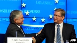 Belgium -- EU Commissioner for Enlargement Stefan Fuele (R) and Armenian Foreign Minister Edward Nalbandian shake hands during a press conference at the EU Headquarters in Brussels, December 9, 2013