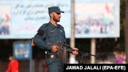 An Afghan police officer stands guard at the site of a suicide bombing in downtown Kabul on July 1.