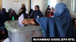 A Afghan woman casts her vote during parliamentary elections in Kandahar on October 27.
