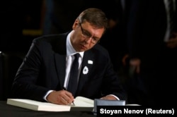 Premierul Aleksandar Vucic semnînd în cartea de condoleanțe
