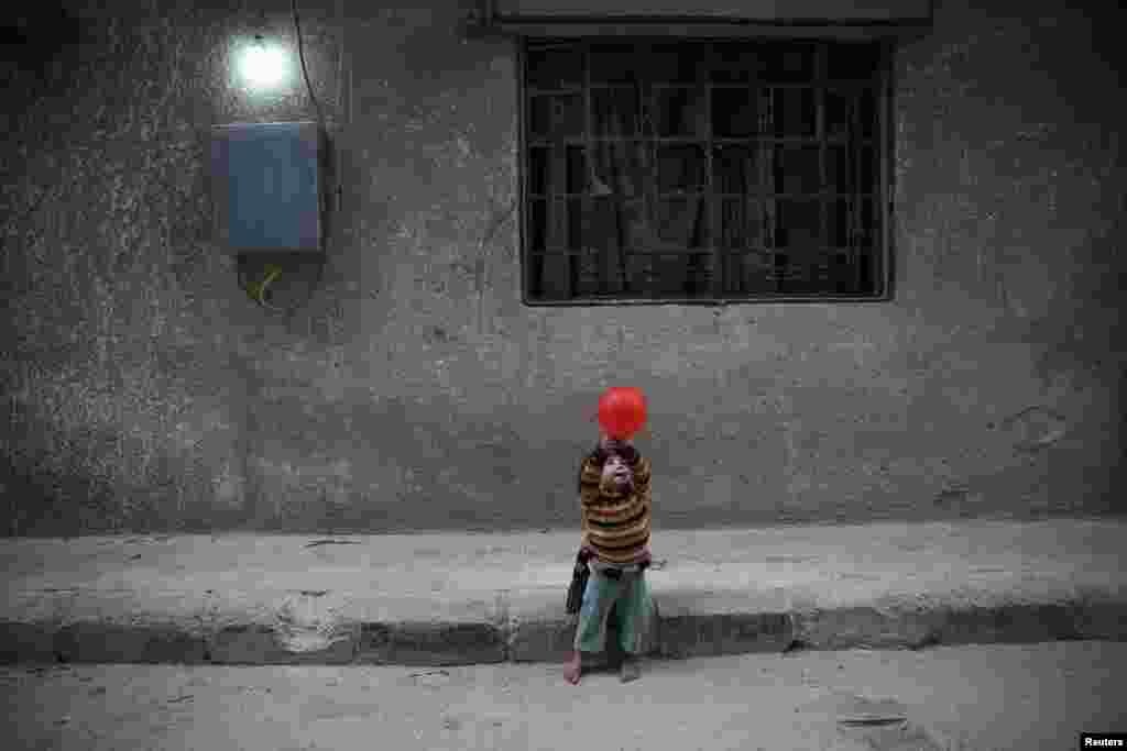 A child plays with a balloon in the besieged, rebel-held city of Douma, in the eastern Damascus suburb of Ghouta. (Reuters/Bassam Khabieh)