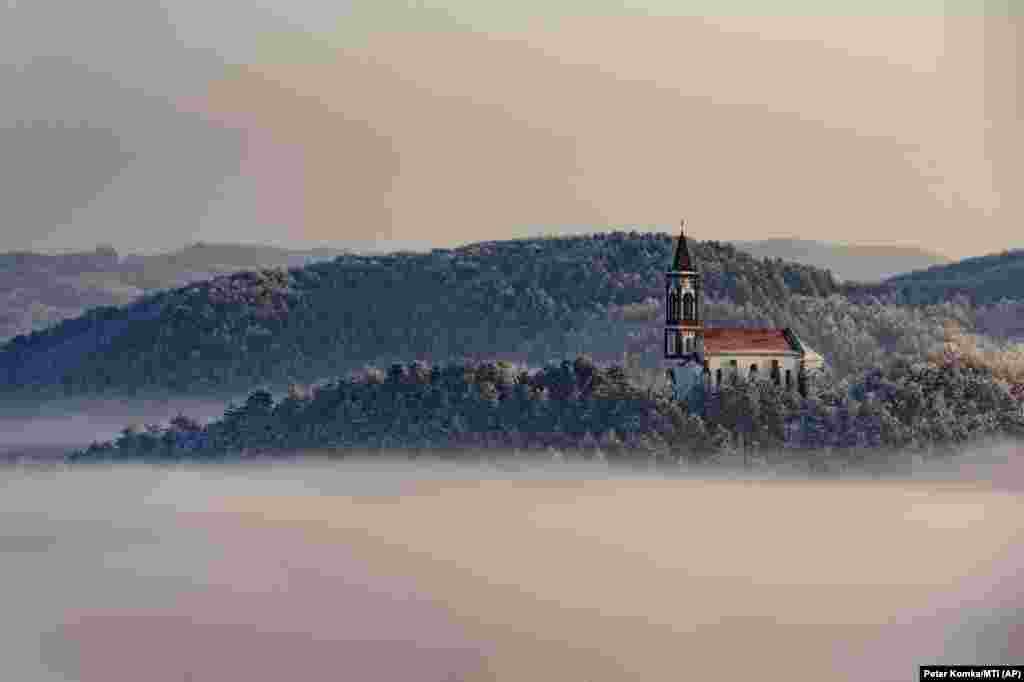 A church stands above a layer of fog in the village of Soshartyan, 115 kilometers northeast of Budapest. (MTI via AP/Peter Komka)