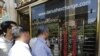 Iranians check exchange rates outside a bank in the capital Tehran. File photo