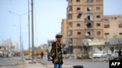 A rebel patrols the severely damaged Tripoli Street in the besieged city of Misurata on April 26.