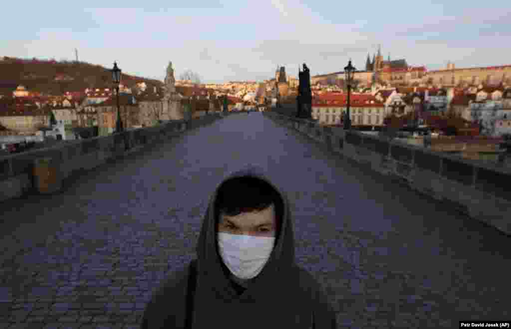 A man wearing a face mask walks across an empty Charles Bridge in Prague. (AP/Petr David Josek)