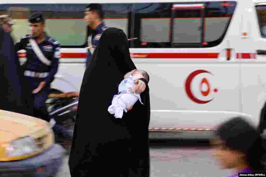 A mother carries her baby in a sttreet in Karbala.