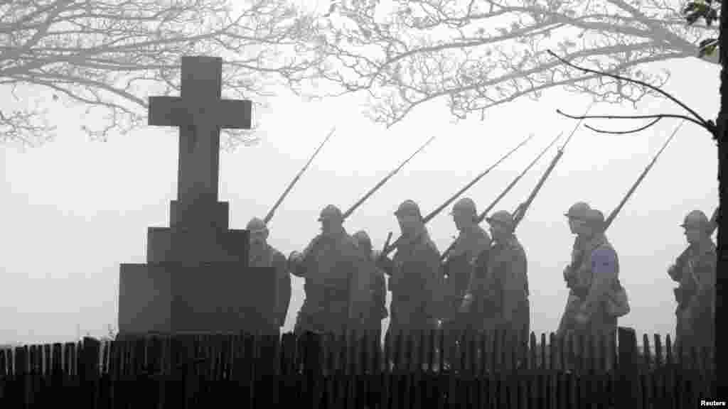 People reenact a historic march wearing World War I-era French military uniforms during Armistice Day ceremonies at France's World War I military cemetery in Notre Dame de Lorette, Ablain Saint Nazaire, France. (Reuters/Pascal Rosssignol)