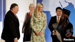 U.S. Secretary of State Mike Pompeo and White House senior advisor Ivanka Trump greet Francisca Awah Mbuli, survivor of human trafficking from Cameroon, during an event to unveil the 2018 Trafficking in Persons (TIP) Report at the State Department in Wash