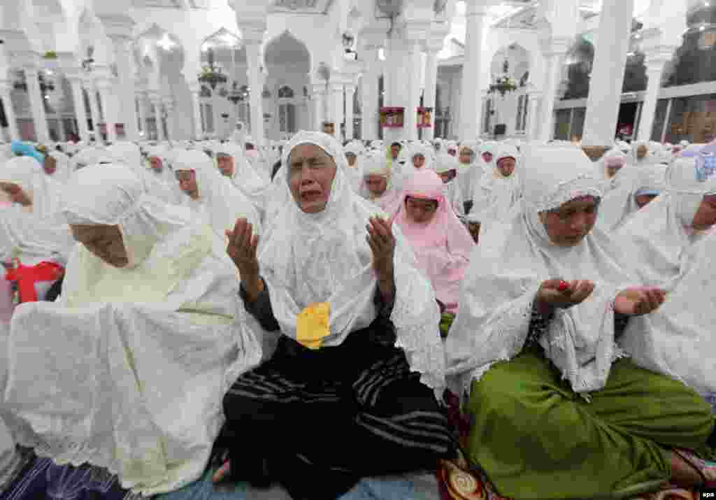 Aceh residents react during a mass prayer at the Baiturrahman mosque in Banda Aceh, Indonesia, to commemorate the victims of the Indian Ocean tsunami in 2004, which claimed the lives of more than 200,000 people. (epa/Adi Weda)