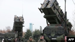 Germany -- Soldiers of the Air Defence Missile Squadron 2 walk past Patriot missile launchers in the background in Bad Suelze, 04Dec2012