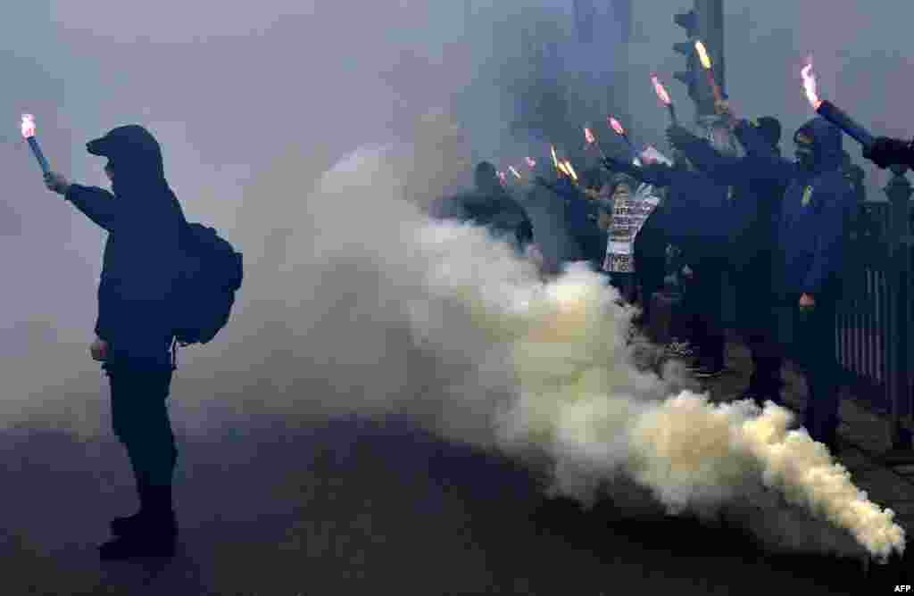 Supporters of various Ukrainian nationalist parties light smoke bombs as they chant slogans during a rally in front of Ukrainian parliament in central Kyiv on February 22. (AFP/Genya Savilov)