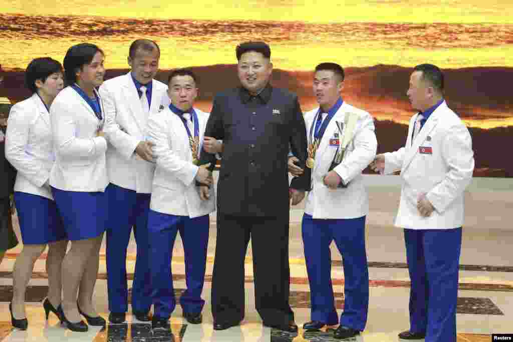 North Korean leader Kim Jong Un meets athletes who won gold medals at the 17th Asian Games and recent world championships and their coaches in this undated photo released by North Korea's Korean Central News Agency (KCNA) in Pyongyang. State media has begun making reports of Kim's public activities after more than 40 days of silence.