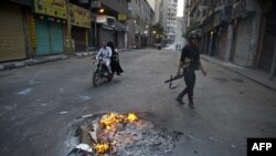 An Egyptian riot policeman takes position in downtown Cairo during clashes with supporters of Egypt's ousted Islamist president Mohammad Morsi on October 6.