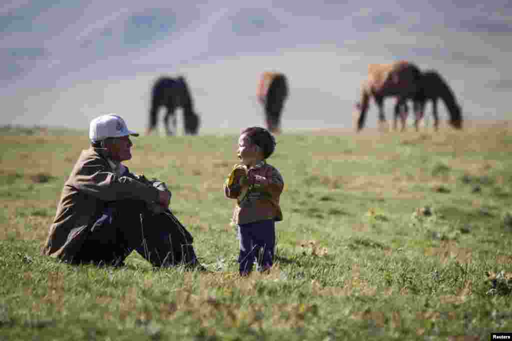 Turgynbay Erkinbekov, 70, talks to his grandson Nurtleu.