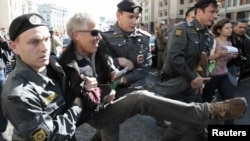 Russian police detain an opposition activist at a rally protesting a bill, initiated in the State Duma, to authorize bigger fines for a broader range of violations at demonstrations.