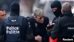 Belgian police take part in a search in the Brussels borough of Schaerbeek following bombings in Brussels in March.