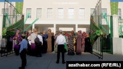 Orta mekdebiň öňünde duran ene-atalar we okuwçylar (Illýustrasiýa suraty)