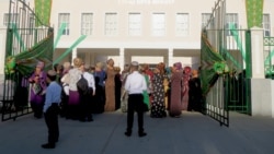 Türkmenistandaky mekdepleriň biriniň daşynda duran bilim işgärleri we ene-atalar (Illýustrasiýa suraty)