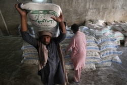 Laborers sort wheat flour sacks at a sale point in the southern seaport city of Karachi on January 20.