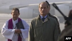 French Defence Minister Gerard Longuet (center) looks on as Foreign Legion soldiers carry the coffins of slain comrades Mohammed El Garrafi and Damien Zingarelli during a ceremony on the runway of Kabul Airport on December 31.