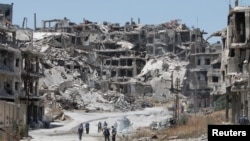 Workers collect the rubble of damaged buildings to be recycled and reused for reconstruction, under the supervision of UNDP) in the government-controlled district of Wadi al-Sayeh in Homs, Syria.