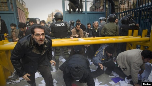 Protesters enter the gate of the British embassy in Tehran, as the police stand by. Nov. 29, 2011