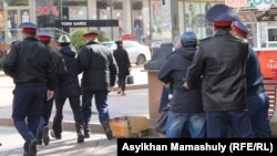 Адамдарды ұстап бара жатқан полиция қызметкерлері (Көрнекі сурет).