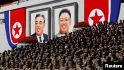 Military officers stand near portraits of North Korean founder Kim Il Sung (left) and late leader Kim Jong Il during a military parade marking the 70th anniversary of North Korea's foundation in Pyongyang on September 9.