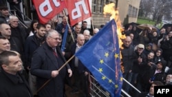 Vojisillav Sheshel me flamurin e ndezur të Bashkimit Evropian gjatë një proteste në Beograd