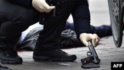 A Ukrainian police expert seizes a gun at the scene where former Russian lawmaker Denis Voronenkov was shot dead in the center of Kyiv on March 23.