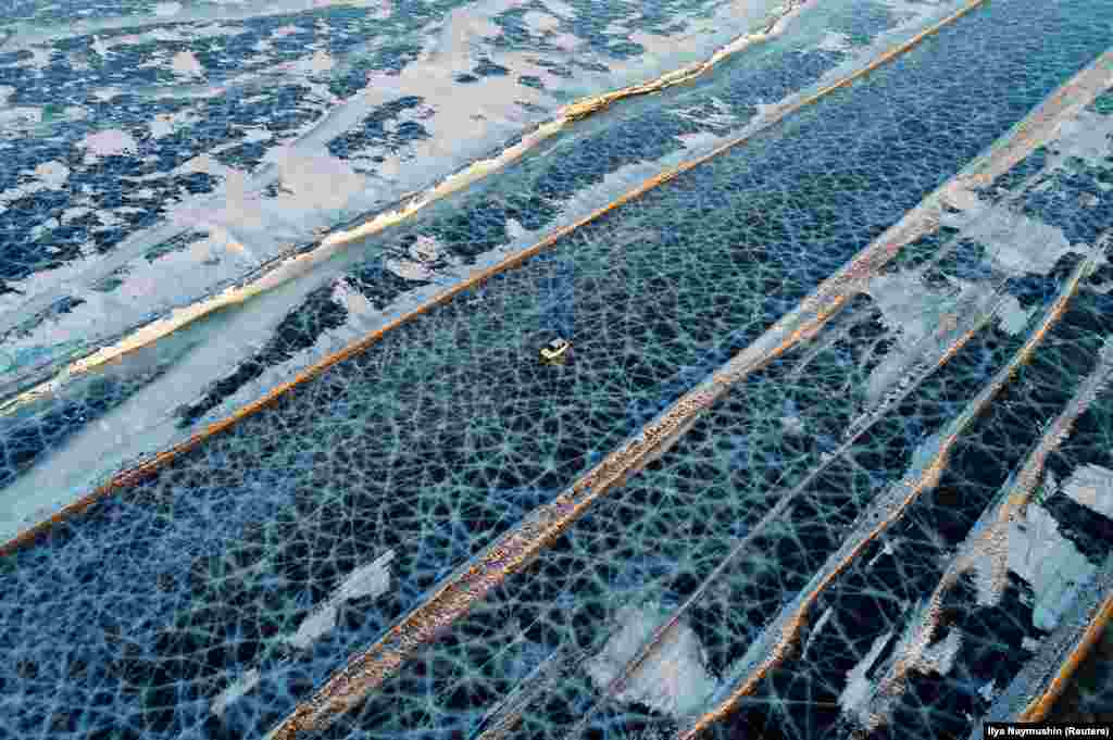 A car drives along a road created during the winter season to connect the banks of the ice-covered Yenisei River, south of Krasnoyarsk, Russia, on March 3. (Reuters/Ilya Naymushin)